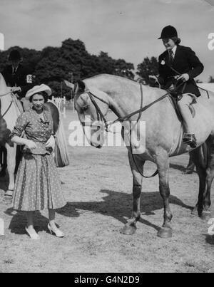 La regina Elisabetta II presenta una rosetta a un vincitore del premio nella Grade 'C' Jumping Competition il primo giorno del Royal Windsor Horse Show a Home Park presso il Castello di Windsor. Foto Stock