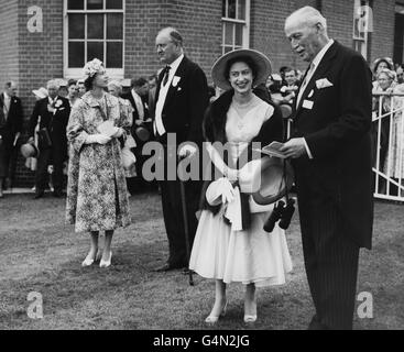 La regina Elisabetta II parla con il suo allenatore, il capitano Cecil Boyd-Rochfort, mentre la principessa Margaret parla con il direttore di corse della regina, il capitano Charles Moore, dopo che la filly della regina, Almeria, aveva vinto i Ribblesdale Stakes alla riunione reale di Ascot. Foto Stock