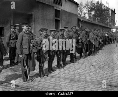 I "Tommies" britannici di vari reggimenti inglesi e scozzesi redatti su una strada acciottolata in Francia sulla loro strada per il fronte durante la prima guerra mondiale. Foto Stock