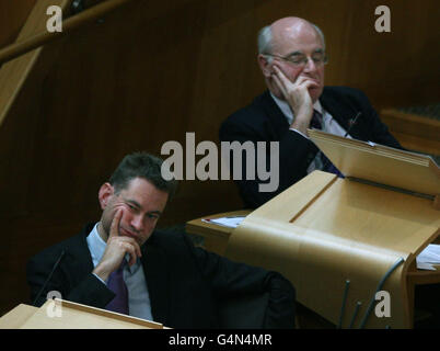 Il conservatore scozzese Murdo Faser MSP (a sinistra), ex leader del partito David McLetchie, guarda al Parlamento scozzese di Edimburgo durante il tempo delle interrogazioni. Foto Stock