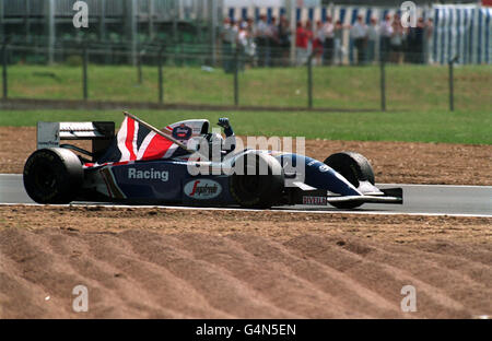 Formula uno Motor Racing - Gran Premio di Gran Bretagna - Silverstone. Damon Hill vola la bandiera sul suo giro di vittoria dopo aver vinto il Gran Premio di Gran Bretagna a Silverstone. Foto Stock