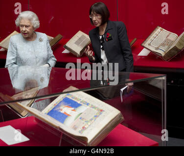 La Regina Elisabetta II, accompagnata dalla curatrice Kathleen Doyle (a destra) guarda le mostre mentre visita la British Library di Londra, dopo aver aperto la mostra intitolata Royal Manuscripts: Il Genius dell'illuminazione. Foto Stock