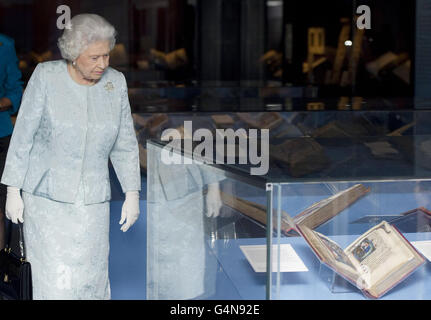 La regina Elisabetta II guarda le mostre mentre tournée nella British Library di Londra, dopo l'apertura della mostra intitolata Royal Manuscripts: The Genius of Illumination. Foto Stock