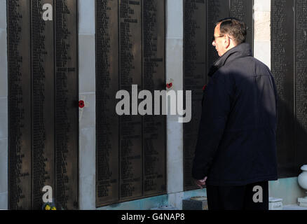 Un uomo paga i suoi rispetti ai nomi sul Cenotaph di Portsmouth durante un servizio sulla Domenica di memoria. Foto Stock