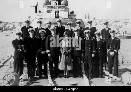 Il Duca di Edimburgo e il Capitano John Edwin Home McBeath DSO, DSC, RN (a sinistra), posa con la Regina Elisabetta II e gli ufficiali di HMS Chequers, durante la visita del giorno di Santo Stefano al cacciatorpediniere che il Duca sta attualmente servendo. Il duca sarebbe stato il comando HMS Chequers Foto Stock