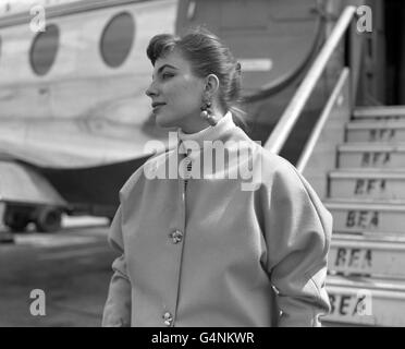 I golosi orecchini a bacca sono indossati dall'attrice Joan Collins, raffigurata mentre saliva a bordo di un BEA Viscount all'aeroporto di Londra sulla strada per Roma. Sarà in Italia per fare un nuovo film con l'attore Jack Hawkins (non illustrato). Foto Stock