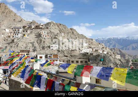 Case sul colle roccioso, bandiere di preghiera, di Leh, Ladakh, Jammu e Kashmir India Foto Stock