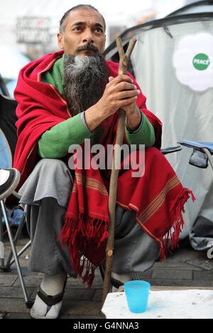 Farhan Rasheed, 41 anni, di Londra siede presso la tenda anonima alla protesta Occupy alla Cattedrale di St Paul, dove la City of London Corporation oggi ha servito un avviso legale sui manifestanti anticapitalisti accampati all'esterno. Foto Stock