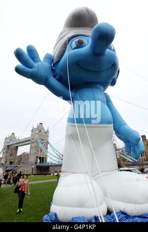 Un grande Puffo gonfiabile accanto al Tower Bridge nel centro di Londra, per promuovere l'uscita dei Puffi su Blu-Ray e DVD il 5 dicembre. Foto Stock