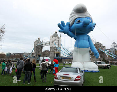 Un grande Puffo gonfiabile accanto al Tower Bridge nel centro di Londra, per promuovere l'uscita dei Puffi su Blu-Ray e DVD il 5 dicembre. Foto Stock