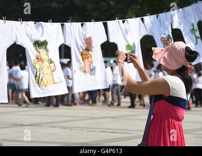 Pechino, Cina. 19 giugno 2016. Un visitatore prende le foto di camicie progettato da giovani artisti nel corso di una conferenza stampa per Beijing Biennale dei Giovani Artisti a Pechino Capitale della Cina, 19 giugno 2016. La biennale si terrà qui in ottobre. © Luo Xiaoguang/Xinhua/Alamy Live News Foto Stock