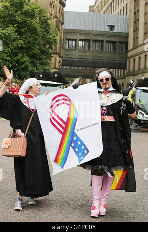 Manchester, Regno Unito. 19 giugno 2016. "Sorella Jacqui Moff' dalla Suore del Perpetuo indulgenza, che è un ente di beneficenza, di protesta, e street performance organizzazione utilizzando trascinare e immagini religiose per evidenziare problemi, tenere un poster di un orgoglio di nastro e le parole "Stiamo con Orlando' unirsi al Mancunian parade di Manchester, UK,19 giugno 2016 Credit: Barbara Cook/Alamy Live News Foto Stock