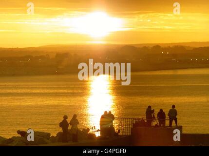 Il sole splende all'alba per circa cinque minuti, mentre gli osservatori dell'eclisse allestiscono treppiedi e telescopi su Mounts Bay, Penzance, Cornovaglia, il giorno dell'ultima eclissi solare totale del ventesimo secolo. * come previsto dalle previsioni meteorologiche, una banca di nube si è spostata attraverso il Sud-ovest , subito dopo questa alba, minacciando di rovinare il partito dell'eclissi in Gran Bretagna. Foto Stock