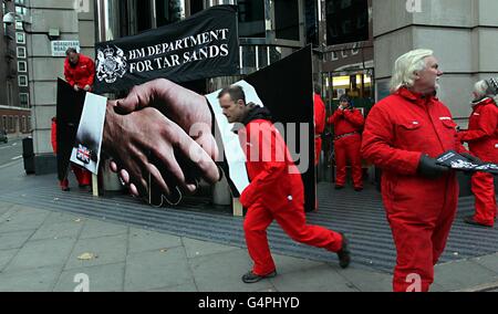 I manifestanti di Greenpeace bloccano l'ingresso al Dipartimento per i trasporti di Horseferry Road, Londra, dopo aver dichiarato che i documenti rilasciati hanno dimostrato come i funzionari del dipartimento dei trasporti stiano lavorando contro una proposta europea chiave che avrebbe bloccato il petrolio di sabbie bituminose, il petrolio più sporco del mondo, Dalla fine in pompe di benzina in tutta Europa. Foto Stock