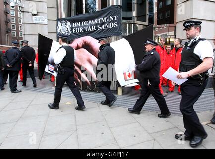 I manifestanti di Greenpeace bloccano l'ingresso principale al Dipartimento dei Trasporti di Horseferry Road, Londra, dopo che hanno chiesto la pubblicazione di documenti che dimostravano come i funzionari del dipartimento dei trasporti stiano lavorando contro una proposta europea fondamentale che bloccherà il petrolio di sabbia catrame, il petrolio più sporco del mondo, Dalla fine in su nelle pompe di benzina in tutta Europa. Foto Stock