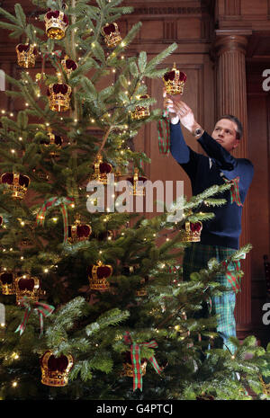 Un albero di Natale alto dieci piedi nella Grande Galleria è decorato dal membro dello staff Andrew Grant al Palazzo di Holyroodhouse, Edimburgo. Foto Stock