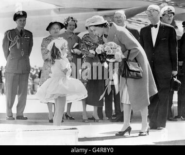 La regina Elisabetta II tiene una conversazione con Dale Russell dopo averla presentata con un bouquet alla base dell'aeronautica di Torbay, vicino a St. John's, Terranova. Il primo ministro di Terranova è Joseph Smallwood, che si erge con orgoglio sulle spalle della regina. È il nonno di Dale. Foto Stock