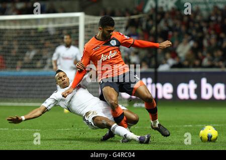 Scott Sinclair di Swansea City (a sinistra) e Queens Park Rangers' Armand Traore (a destra) battaglia per la palla Foto Stock