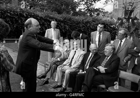 Il leader del lavoro Neil Kinnock fa il suo Tommy Cooper agire come egli chiede l'ordine dal suo nuovo gabinetto ombra che si prepara per la fotocellula di oggi fuori della Camera del Parlamento. Seduti nella parte anteriore sono a sinistra: Dr. John Cunningham, Derek Foster, Gerald Kaufman e Roy Hattersley. In piedi da sinistra: Bryan Davies, Secretriy del Partito laburista parlamentare, Jack Straw, Gordon Brown e Lord Cledwyn Foto Stock