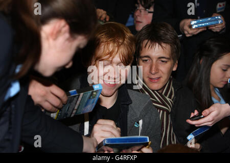 Gli attori di Harry Potter Rupert Grint (centro, sinistra) e Oliver Phelps (centro, destra) firmano le copie dei DVD mentre pagano una visita a sorpresa alla scuola del vescovo Walsh RC a Sutton Coldfield. Foto Stock