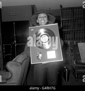 La cantante Shirley Bassey con un disco d'oro le ha assegnato un per il suo disco The Shirley Bassey Singles Album e le ha presentato all'aeroporto di Heathrow quando è arrivata da Roma. È il suo primo disco d'oro britannico, anche se ha 16 da altri paesi. Mentre tornerà a casa sarà apparsa in Top of the Pops cantando la sua nuova canzone, 'Good Bad but beautiful'. Foto Stock