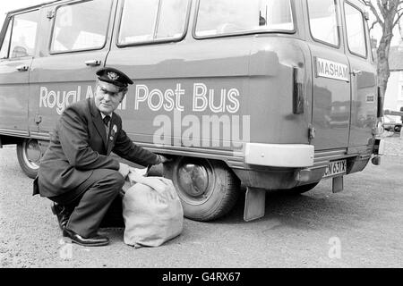 Il postino Roger Swiers esamina un pneumatico sul primo Royal Mail Post Bus nel suo viaggio inaugurale tra Ripon e Masham. Un hold-up si è verificato nel villaggio di Masham, North Yorkshire, come la replica vittoriana posta diligenza accompagnarlo sul viaggio ha rotto il suo gancio di traino. Foto Stock