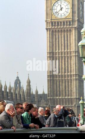 Gruppi di spettatori sul Westminster Bridge di Londra assistono al sollevamento finale della ruota panoramica British Airways London Eye (non raffigurata). Foto Stock