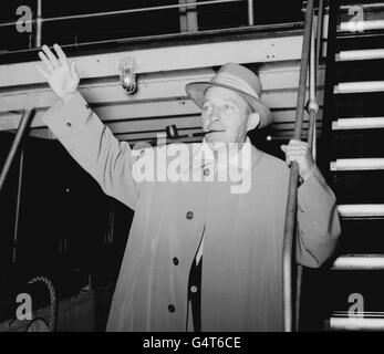 Bing Crosby saluta un saluto quando arriva a Plymouth a bordo del liner 'Liberte' da New York. Foto Stock