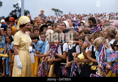 La Regina incontra i bambini delle scuole che sventolano la bandiera all'arrivo a Brisbane, durante il suo Silver Jubilee Tour of Australia. Foto Stock