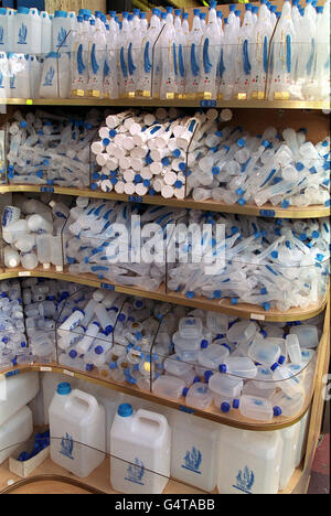 Scaffali riempiti con bottiglie di plastica di acqua Santa in vendita a Lourdes, Francia. Foto Stock