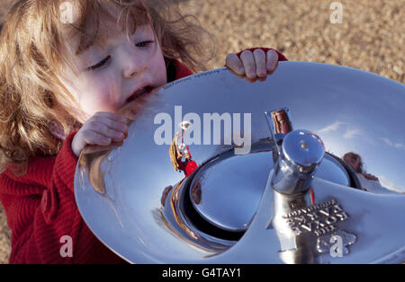 Poppy Ellis-Jones di 3 anni e un trombettiere della Band of the Life Guards (riflessa) aiutano la Royal Parks Foundation a segnare l'arrivo della Tiffany Drinking Fountain nei Kensington Gardens di Londra, Che è stato progettato da ben Addy di Moxon Architects - vincitore di un concorso internazionale di design per trovare 'la fontana da bere Ultimate' per i Parchi reali. Foto Stock