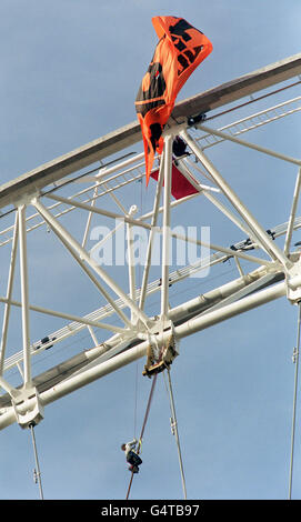 Un dimostratore svanola un banner sulla nuova ruota Millennium Wheel, alta 450 metri, vicino al Tamigi. Fino a dieci attivisti del gruppo basco, Solidarios con Itoitz, e del gruppo indiano, Narmada UK, hanno eluso la sicurezza prima di svelare i banner. * si oppongono alla costruzione di dighe nei Paesi Baschi in Spagna e in India. La ruota da 1,500 tonnellate, conosciuta ufficialmente come London Eye, è stata infine trascinata in posizione eretta sulla riva sud del Tamigi. Offrendo una vista spettacolare sulla capitale, sarà aperto la vigilia del Millennio e rimarrà in posizione per almeno cinque anni. Foto Stock