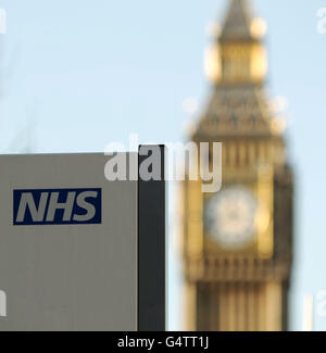 Un cartello NHS al St Thomas' Hospital, con il Big ben sullo sfondo, a Westminster, nel centro di Londra Foto Stock