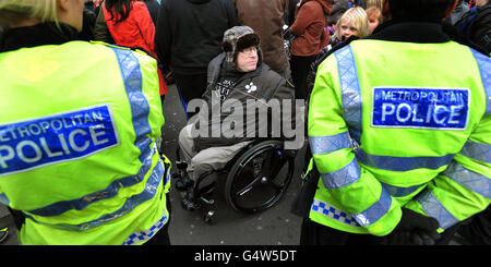 Un protesto (nome non noto) in sedia a rotelle e polizia durante una dimostrazione in cui un gruppo di manifestanti legati alla sedia a rotelle si sono incatenati insieme attraverso Regent Street a Oxford Circus, Londra, mentre protestano contro il Welfare Reform Bill del governo. PREMERE ASSOCIAZIONE foto. Data foto: Sabato 28 gennaio 2012. I membri del gruppo di azione diretta UK Uncut e i gruppi di campagna per la disabilità hanno cantato, ondulato striscioni e bangato tamburi nel mezzo di Oxford Circus, bloccando il suo collegamento con Regent Street. I gruppi stanno esprimendo la loro rabbia per l'impatto del Welfare Reform Bill, avvertimento Foto Stock