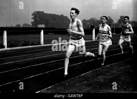 MARZO 23: In questo giorno, nel 1929, nacque Sir Roger Banister. Bannister ha recentemente lanciato la nuova moneta Royal Mint 50p per commemorare il 50° anniversario del suo record sub Four minute Mile il 6 maggio 1954. Roger Banister (fronte) rappresenta l'Università di Oxford durante l'evento Inter-Varsity Mile alla White City di Londra Foto Stock