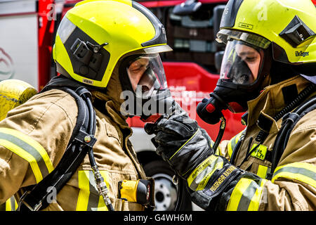 I vigili del fuoco durante un esercizio, con attrezzature di protezione respiratoria, di spegnere il fuoco Foto Stock