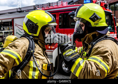 I vigili del fuoco durante un esercizio, con attrezzature di protezione respiratoria, di spegnere il fuoco Foto Stock