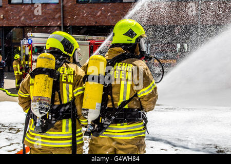 I vigili del fuoco durante un esercizio, con attrezzature di protezione respiratoria, di spegnere il fuoco Foto Stock