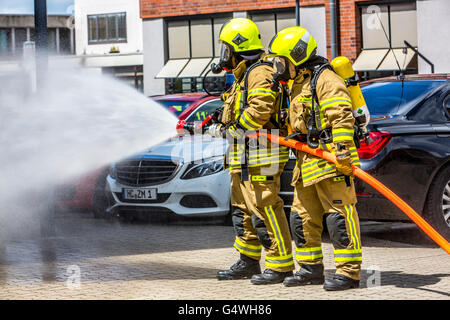 I vigili del fuoco durante un esercizio, con attrezzature di protezione respiratoria, di spegnere il fuoco Foto Stock