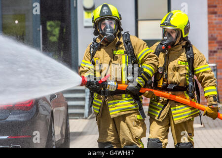 I vigili del fuoco durante un esercizio, con attrezzature di protezione respiratoria, di spegnere il fuoco Foto Stock