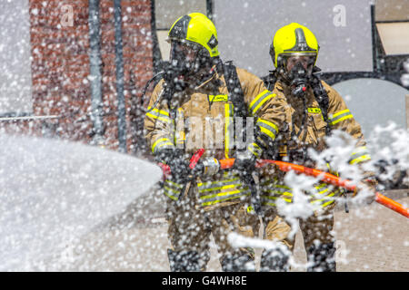 I vigili del fuoco durante un esercizio, con attrezzature di protezione respiratoria, di spegnere il fuoco Foto Stock