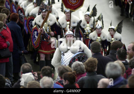 La 'squadra Jarl' di guizzatori - Shetlanders vestita in costume vichingo prima di mettere il fuoco alla Galley, una longship di legno di 30 piedi, mentre canta la 'Casa del Norseman' a Lerwick, Isole Shetland, come parte del tradizionale festival pagano di Up Helly AA. * Up Helly AA ha avuto origine come festival pagano del Norse e poi è stato adottato dai cristiani per celebrare la fine del periodo santo cristiano con il digiuno e i falò. Foto Stock