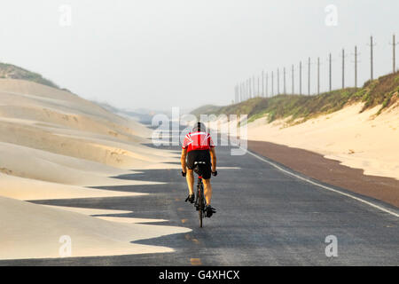 Ciclista su South Padre Island Park Road 100 - Texas - USA Foto Stock