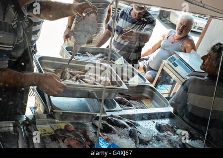 I pescatori discutere ed esaminare un nuovo cattura del pesce a Iraklion, sull'isola di Creta in Grecia Foto Stock