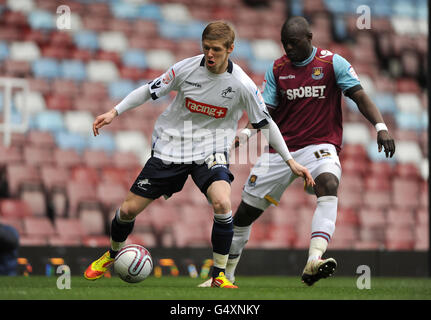 Andrew Keogh di Millwall (a sinistra) e Abdoulaye Faye di West Ham United (destra) in azione Foto Stock