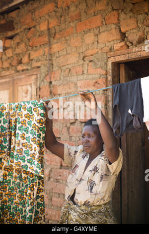 Una donna si blocca il lavaggio esterno la sua casa nel quartiere Kasese, Uganda, Africa orientale. Foto Stock