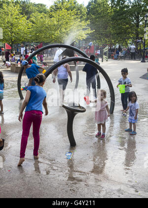 I bambini si divertono e rinfrescarsi a spruzzo di acqua area in corrispondenza di un parco giochi nel Prospect Park di Brooklyn, NY Foto Stock