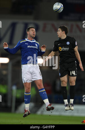 Anthony Gerrard di Cardiff City si dirige a distanza dal Tommy Rowe di Peterborough United durante la partita del campionato di calcio di Npower al Cardiff City Stadium di Cardiff. Foto Stock