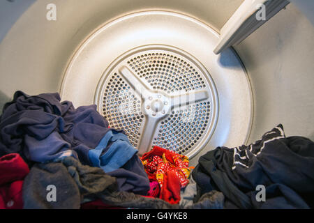 Vista interna di un domestico asciugatrice a tamburo (asciugabiancheria) con abbigliamento in esso Foto Stock