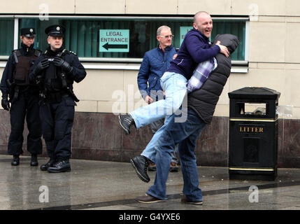 Samuel Higgins, 36, (a destra) si congratula con un maschio non identificato, in quanto lascia Belfast Crown Court dopo essere stato assolto dall'assassinio del capo della Ulster Defense Association (UDA) Tommy English, 40, Che è stato sparato giù nella sua casa in Newtownabbey, Co Antrim davanti a sua moglie e tre bambini piccoli la notte di Halloween in 2000. Foto Stock